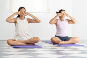 two beautiful women practicing pranayama at home